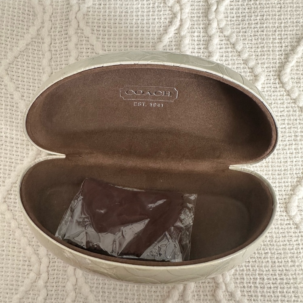 Coach sunglass case, good worn condition. Cleaner rag included unopened.